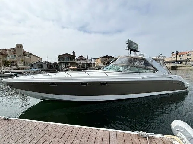 Slide: The Image of A gray and white motor yacht docked in a residential area. - 15
