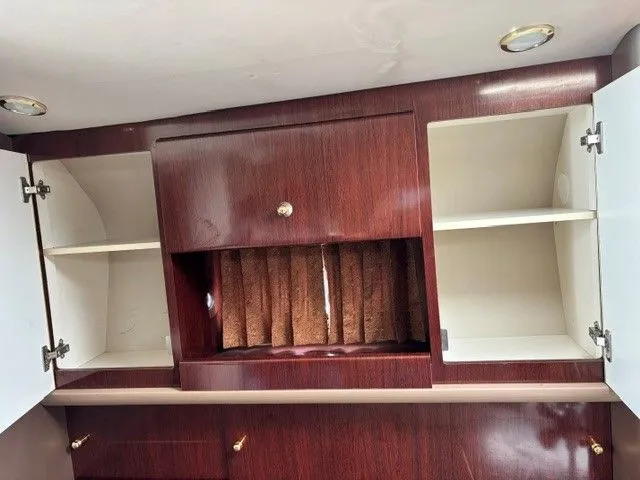 Slide: The Image of An elegant wooden cabinet with open doors and shelves, part of a boat interior. - 6