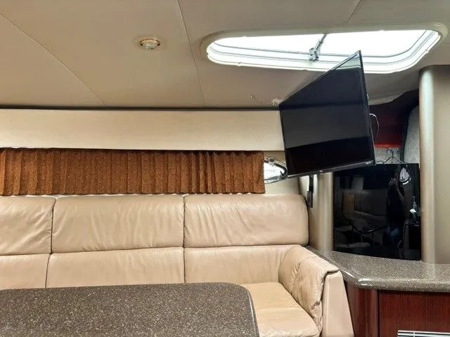 Slide: The Image of Interior of a 2003 Formula 400 Super Sport with beige leather sofa, curtains, and a flat-screen TV. - 12