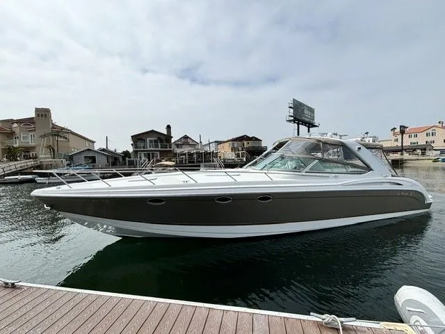 Slide: The Image of A 2003 Formula 400 Super Sport docked in a calm harbor, surrounded by waterfront homes. - 14