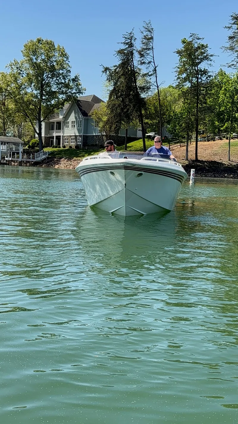 Slide: The Image of A white boat on a calm lake with two people on board. Trees and a house are in the background. - 3