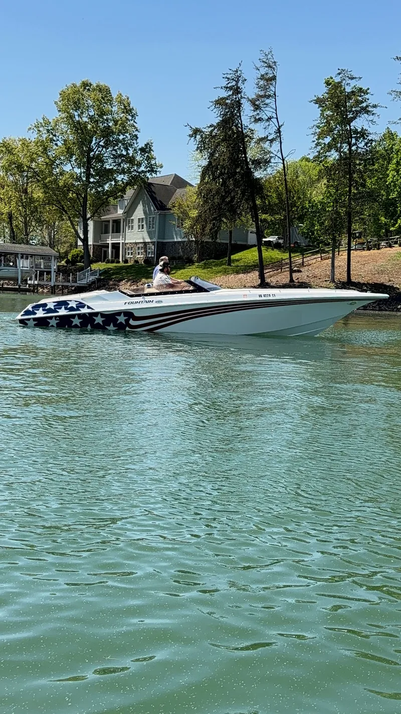 The Image of A white speedboat with American flag design cruises on a calm lake. - 1