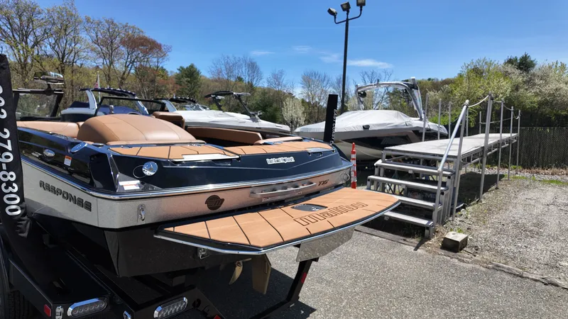 Slide: The Image of A 2025 Malibu TXi boat is on a trailer in an outdoor setting. - 6