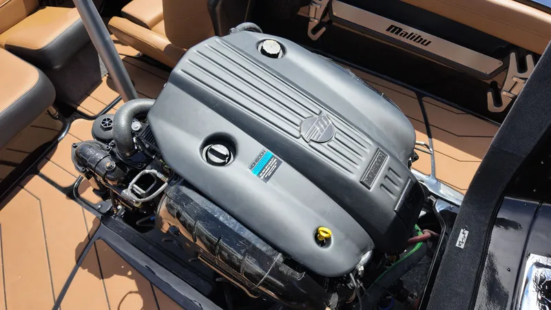 Slide: The Image of The 2025 Malibu TXi features a powerful engine inside the boat with beige seating. - 19