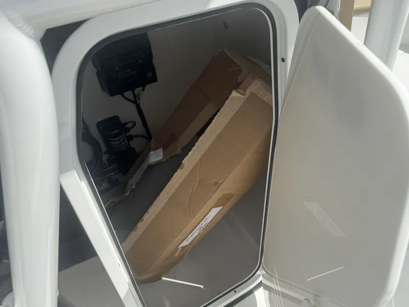 Slide: The Image of An open storage compartment on a boat with a cardboard box and electronic equipment. - 4