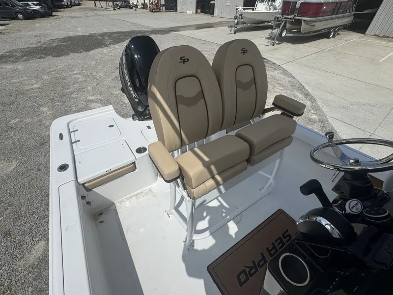Slide: The Image of The image shows the cockpit of a Sea Pro 230 DLX boat with beige seats and a helm. - 6