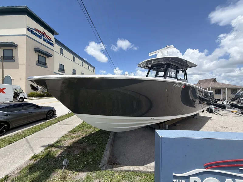 Slide: The Image of A black 2021 Sportsman Open 322 Center Console boat on a trailer beside a building. - 10