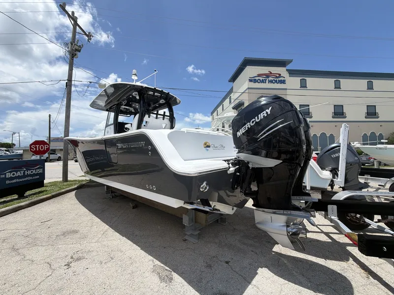 Slide: The Image of A 2021 Sportsman Open 322 Center Console boat on a trailer in front of a building. - 7
