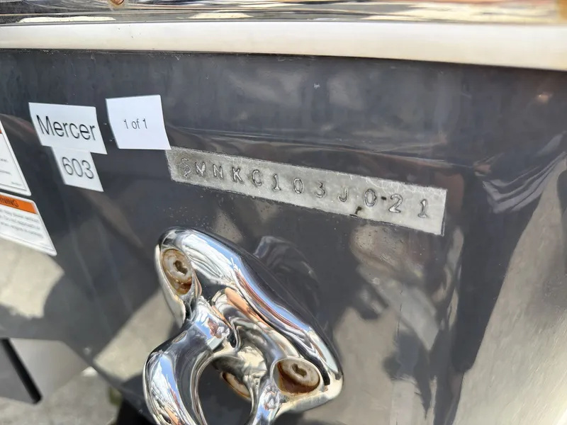 Slide: The Image of Close-up of a boat detail showing a serial number and shiny metal fitting. - 24