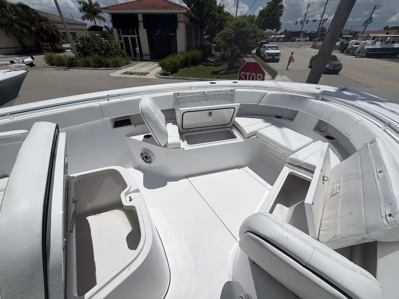 Slide: The Image of The image shows the bow area of a 2021 Sportsman Open 322 Center Console boat with white upholstery. - 25