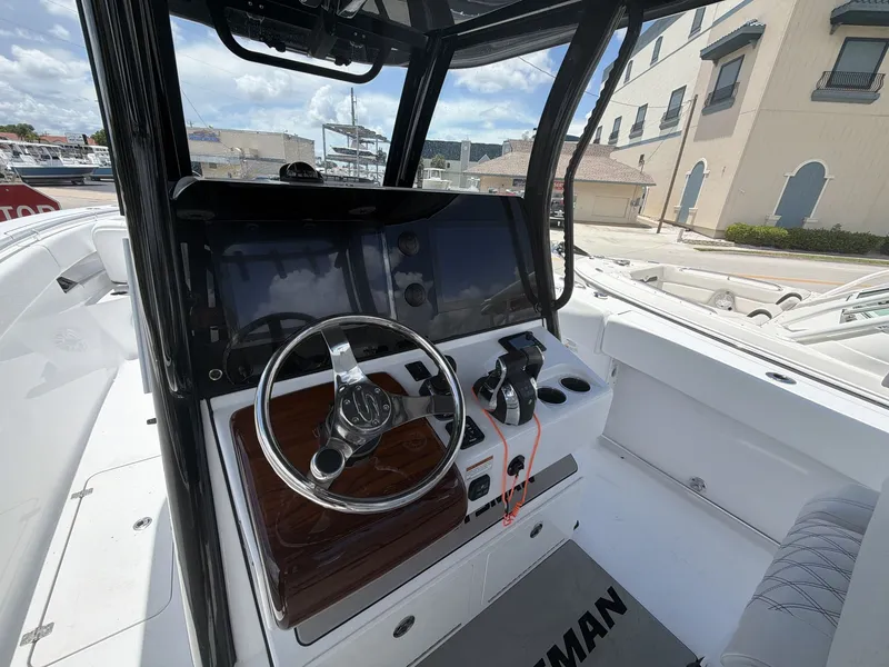 Slide: The Image of The image shows the helm of a 2021 Sportsman Open 322 Center Console boat with modern instruments. - 23