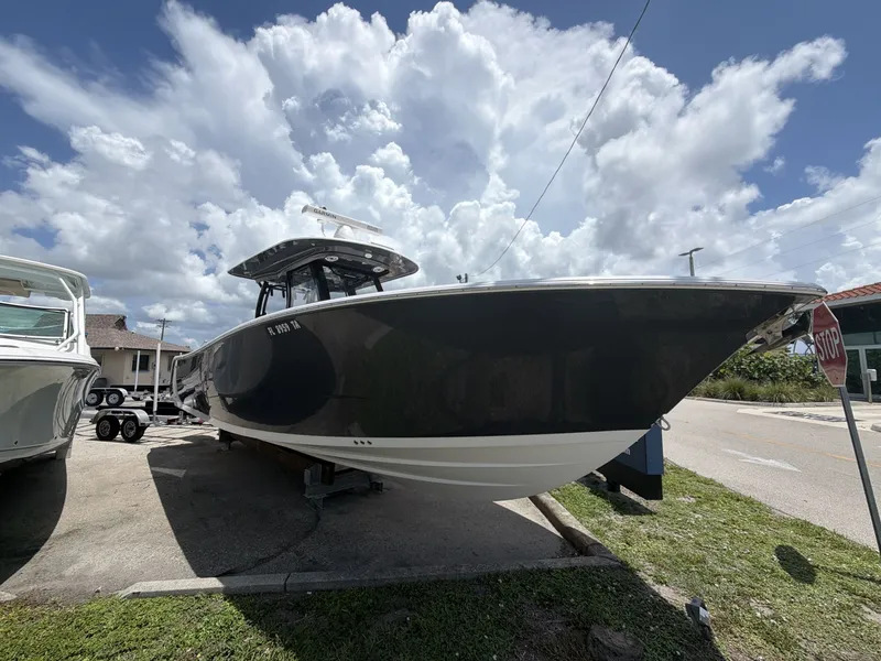 Slide: The Image of A 2021 Sportsman Open 322 Center Console boat on a trailer under a cloudy sky. - 15