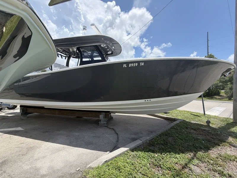 Slide: The Image of A black 2021 Sportsman Open 322 Center Console boat on a trailer under a blue sky. - 4
