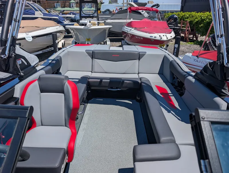 Slide: The Image of The image shows the interior of a 2025 MasterCraft NXT 23 boat with gray and red seating. - 7