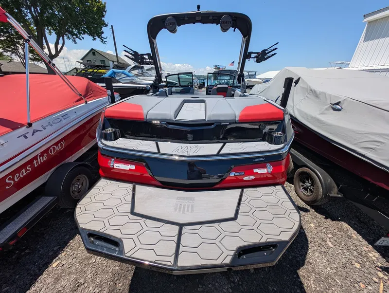 Slide: The Image of The image shows the rear of a 2025 MasterCraft NXT 23 boat with gray and red design. - 4