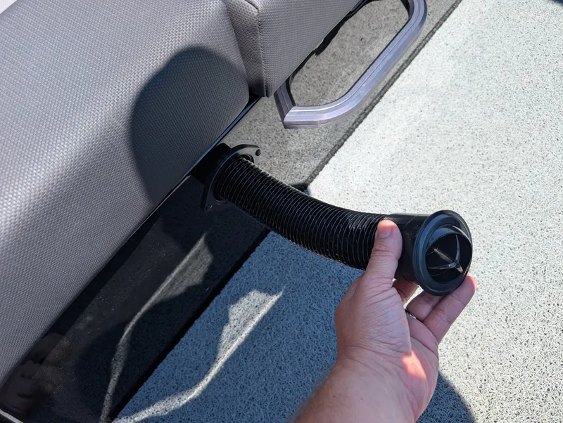 Slide: The Image of A hand holds a flexible hose attached to a gray boat seat. - 19