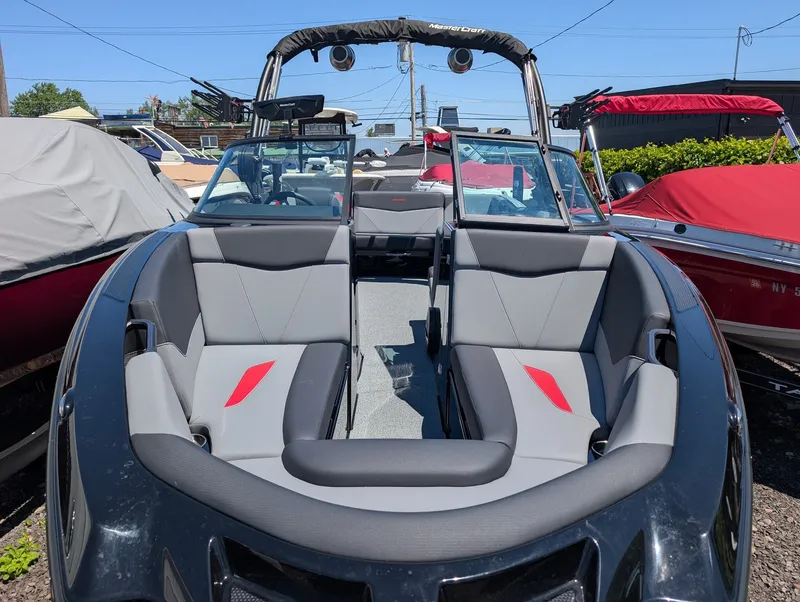 Slide: The Image of The image shows a 2025 MasterCraft NXT 23 boat with gray and red seating. - 6