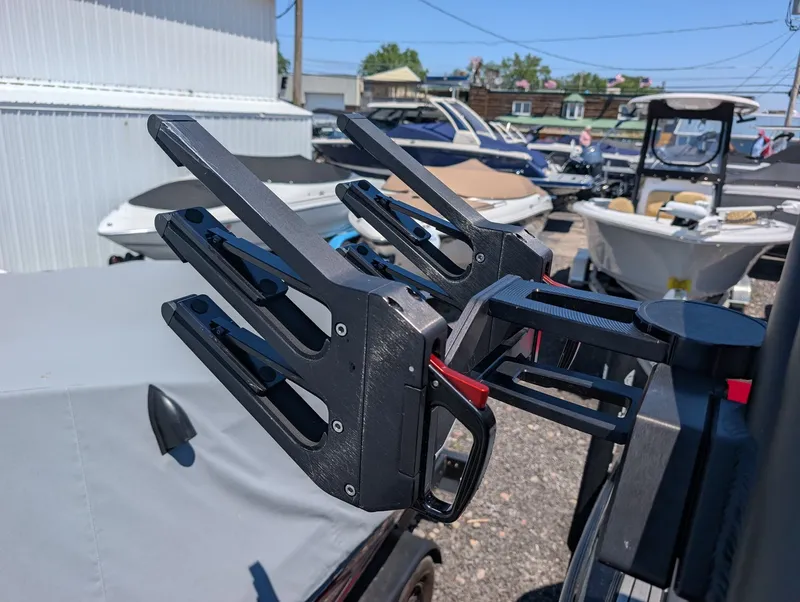 Slide: The Image of A modern wakeboard rack on a MasterCraft NXT 23 boat, surrounded by other boats outdoors. - 14