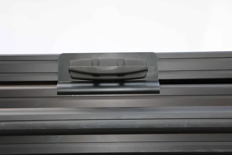 Slide: The Image of Close-up of a black, modern boat handle on a textured surface. - 16