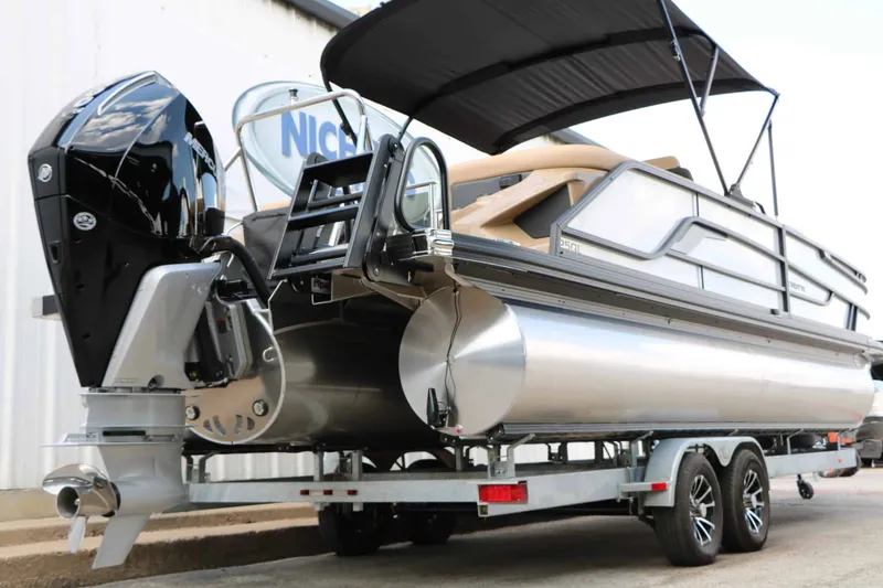Slide: The Image of The image shows a modern pontoon boat on a trailer. It features a large outboard motor and a sunshade. - 14