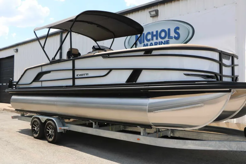 Slide: The Image of A 2026 Evotti 725 QL pontoon boat on a trailer in front of a building. - 26