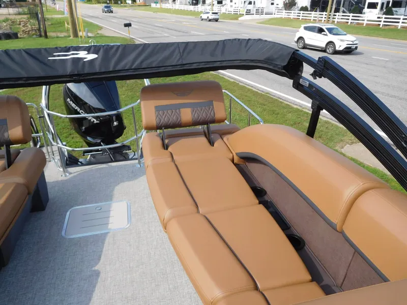 Slide: The Image of The image shows the deck of a Bennington 24 MSL pontoon boat with brown leather seating. - 12