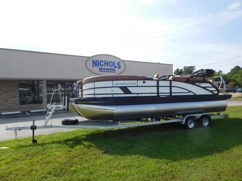 Slide: The Image of Bennington 24 MSL pontoon boat on a trailer in front of a building. - 2