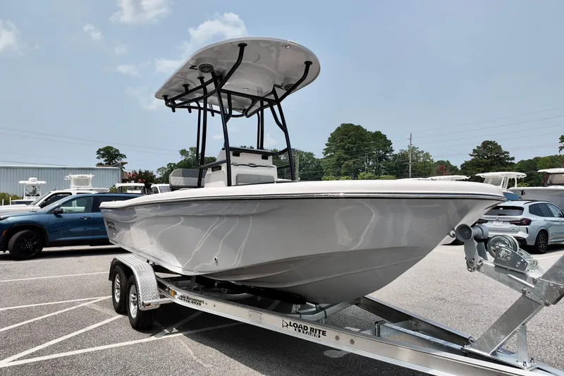Slide: The Image of 2027 Carolina Skiff 21 Ultra Elite boat on trailer, parked outdoors under clear sky. - 17