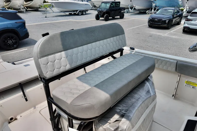 Slide: The Image of 2027 Carolina Skiff 21 Ultra Elite boat interior with cushioned seating in a marina. - 12