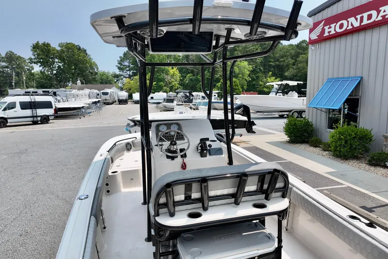 Slide: The Image of 2027 Carolina Skiff 21 Ultra Elite boat at dealership, featuring center console and T-top. - 15