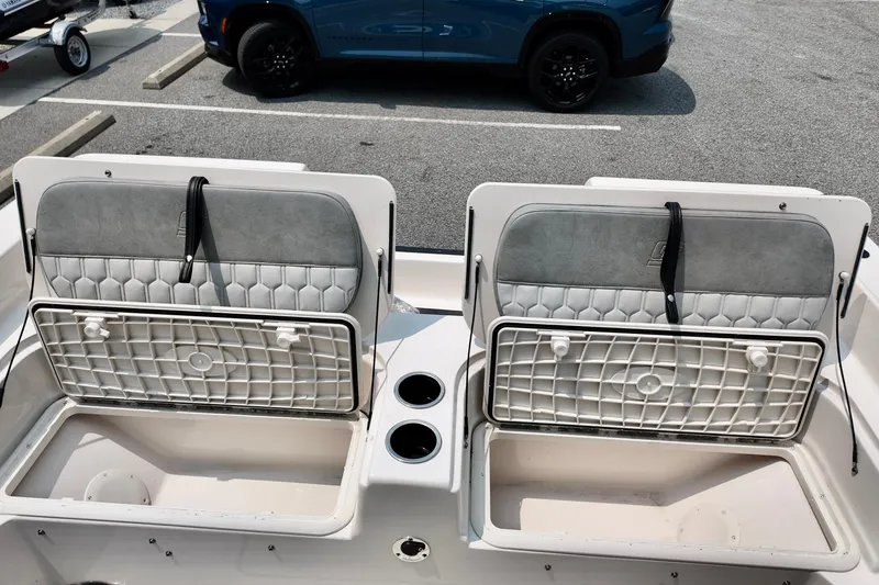 Slide: The Image of 2027 Carolina Skiff 21 Ultra Elite boat storage compartments with cushioned seats. - 13