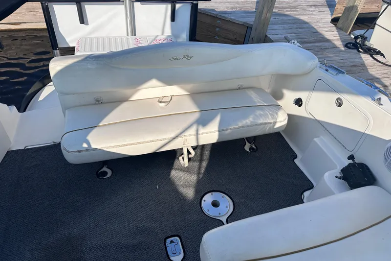 Slide: The Image of 2003 Sea Ray Sundancer 280 boat interior with white seating and carpeted floor. - 11