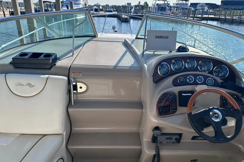 Slide: The Image of 2003 Sea Ray Sundancer 280 helm with steering wheel, gauges, and navigation equipment at marina. - 23