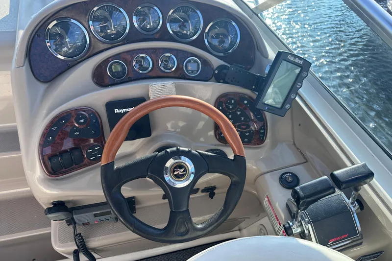 Slide: The Image of Dashboard of a 2003 Sea Ray Sundancer 280 boat with steering wheel and gauges. - 13