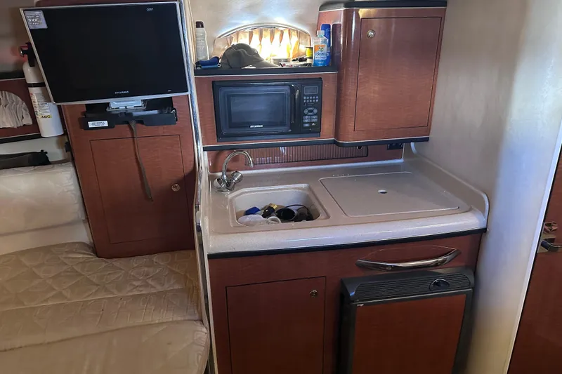 Slide: The Image of Interior of 2003 Sea Ray Sundancer 280 with kitchenette, TV, and storage cabinets. - 21