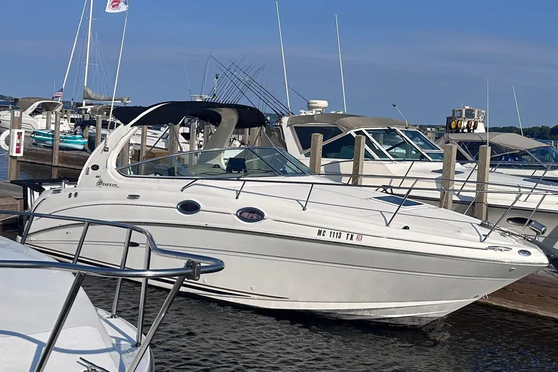 Slide: The Image of A white 2003 Sea Ray Sundancer 280 boat docked, with other boats visible in the background. - 1