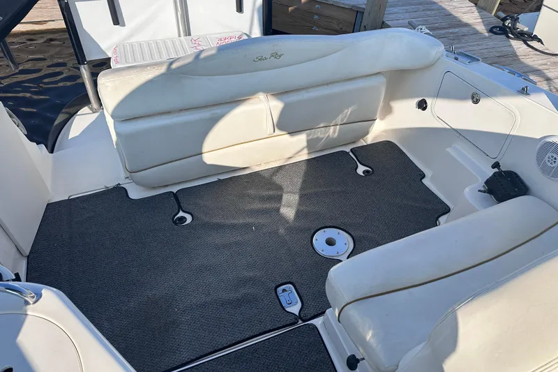 Slide: The Image of 2003 Sea Ray Sundancer 280 boat interior with cushioned seating and carpeted flooring. - 10
