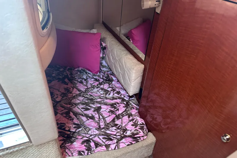 Slide: The Image of Interior cabin of 2003 Sea Ray Sundancer 280 with pink bedding and wood paneling. - 22
