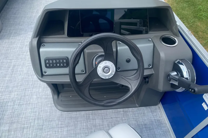 Slide: The Image of Steering console of 2026 Sun Tracker Party Barge 18 DLX with modern controls and cup holder. - 9