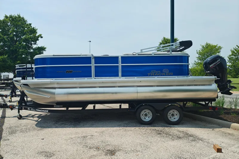 The Image of 2026 Sun Tracker Party Barge 20 DLX pontoon boat on trailer in parking lot. - 1