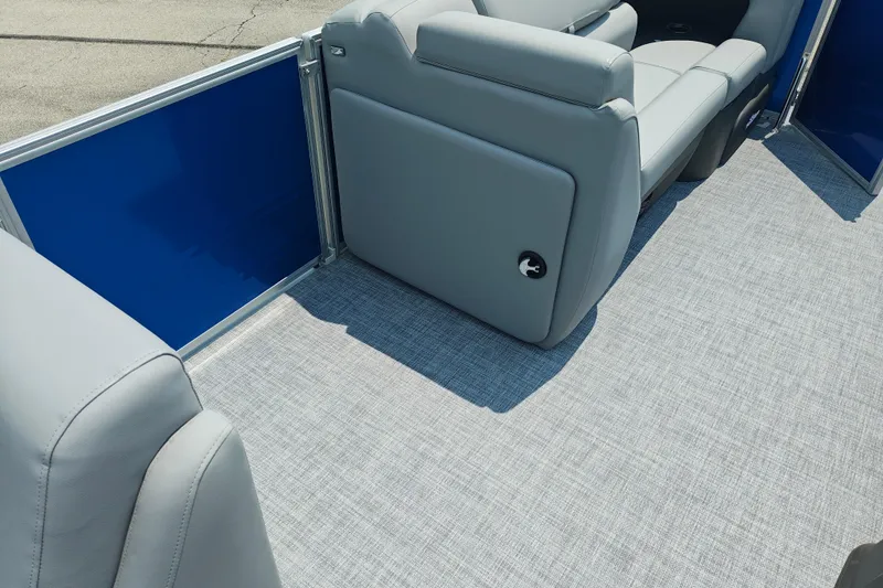 Slide: The Image of 2026 Sun Tracker Party Barge 20 DLX interior with gray seating and blue paneling. - 23