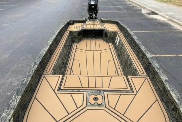 Slide: The Image of 2026 Tracker Grizzly 1650 T Prairie Wings Edition boat with camo design in parking lot. - 18