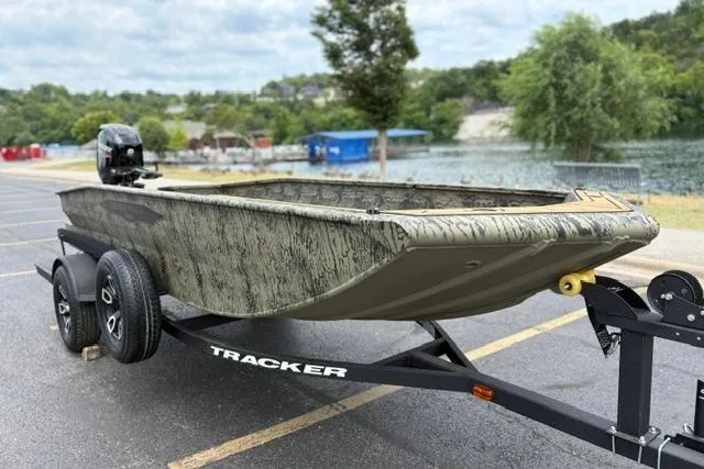 Slide: The Image of 2026 Tracker Grizzly 1650 T Prairie Wings Edition boat on trailer by a lake. - 4