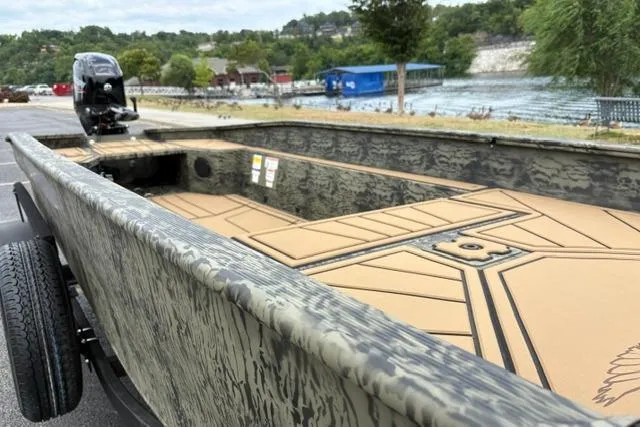 Slide: The Image of 2026 Tracker Grizzly 1650 T Prairie Wings Edition boat with camouflage design near a scenic lake. - 15