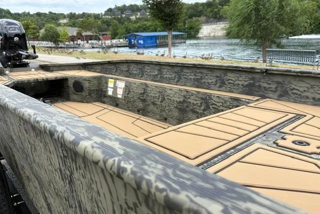 Slide: The Image of 2026 Tracker Grizzly 1650 T Prairie Wings Edition boat with camouflage design by a lakeside. - 14