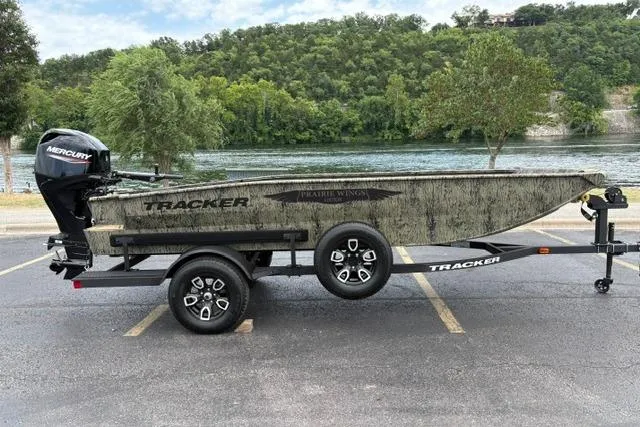 The Image of 2026 Tracker Grizzly 1650 T Prairie Wings Edition boat on trailer by a river. - 0