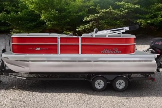 The Image of 2026 Sun Tracker Party Barge 20 DLX pontoon boat on trailer, parked outdoors. - 0
