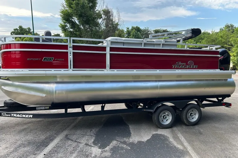 The Image of 2026 Sun Tracker SportFish 20 DLX pontoon boat on trailer, parked outdoors. - 0