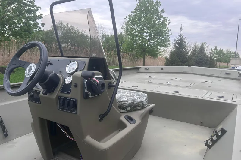 Slide: The Image of 2026 Tracker Grizzly 2072 CC boat interior with steering console and seating. - 2
