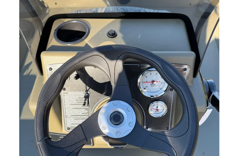 Slide: The Image of Steering console of 2026 Tracker Grizzly 2072 CC with gauges and cup holder. - 3